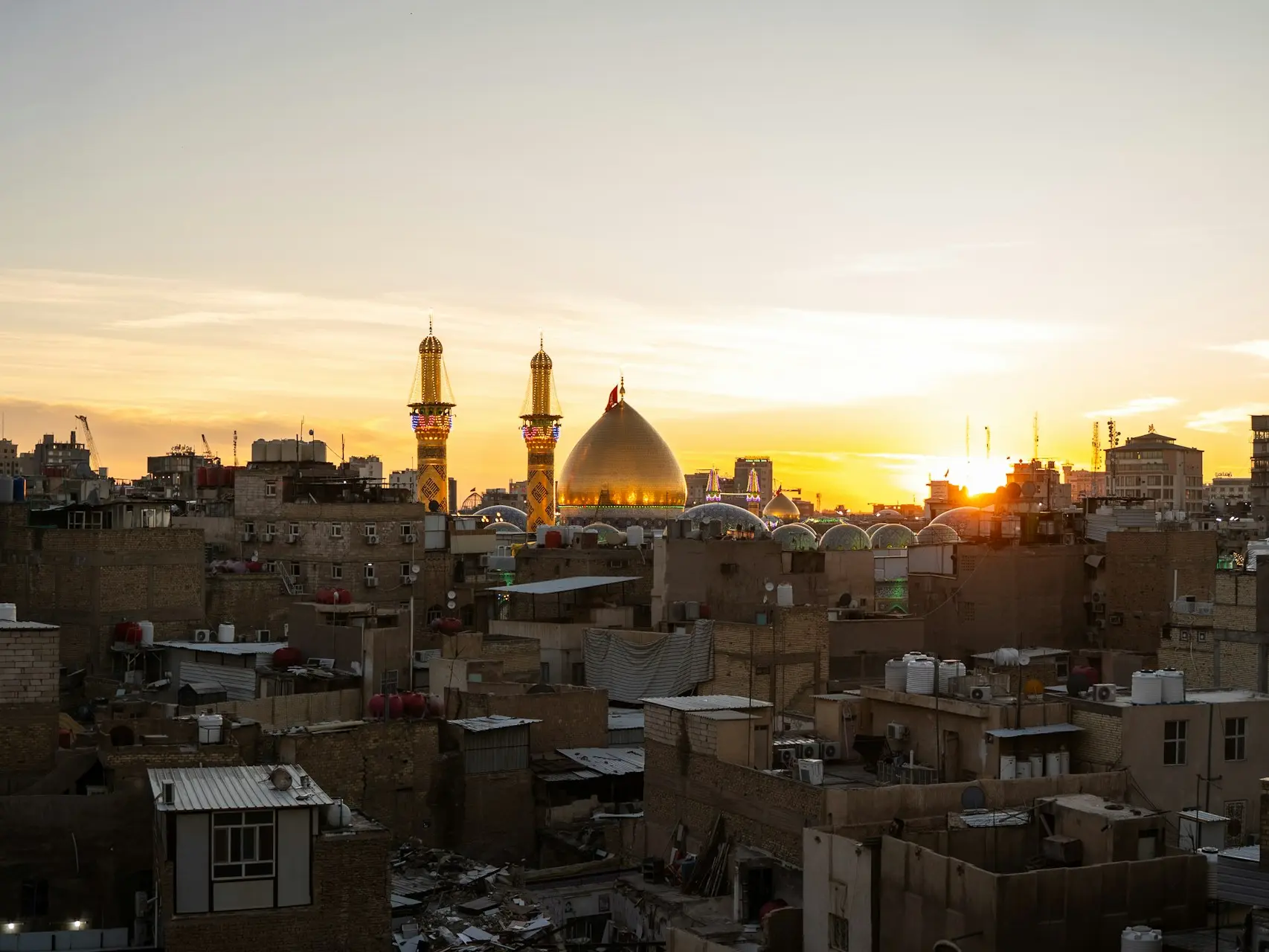 The sun is setting over a city with tall buildings